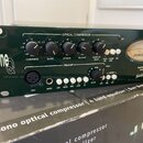 Zelený rackový procesor s nápisem one Q. Horní část tvoří OPTICAL COMPRESSOR s knoflíky Compress, Slope, Atack, Release a Make Up Gain, spodní část P…