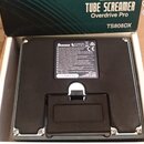 Fotografie zachycuje spodní stranu kytarového efekt pedálu v bílém originálním boxu. Na spodní černé ploše je vidět logo Ibanez a štítek s technickým…