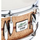 Detailní pohled na snare drum s korpusem z pleteného dřeva v přirozené barvě a chromovaným obručováním. Na korpusu je čtvercový štítek s nápisy „BENN…