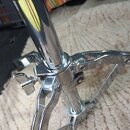 Detail chromovaného kovového stojanu s teleskopickým mechanismem. Na fotce je vidět spojovací uzel s utahovacím šroubem a dvěma rameny. Povrch je les…