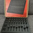 Černý MIDI kontrolér Novation Launchcontrol XL s řadou otočných knoflíků, posuvníků a tlačítek. Na zařízení je v levém horním rohu nápis LAUNCHCONTRO…