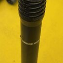 Černý dynamický mikrofon s kovovou síťkou. Na těle je bílý nápis SHURE SM58. Povrch mikrofonu vykazuje známky opotřebení a odřeniny, zejména v horní…