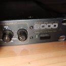Černý rackový přístroj s nápisy SERIES 9000 a Guitar Pre-amp Model 9001. Na předním panelu jsou dva černé otočné ovratky s popisky OUTPUT, MIX a FULL…