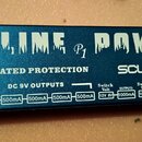 Modrý kovový napájecí zdroj s bílými nápisy. Na horní straně je velký text GALINE P1 POWER a pod ním nápisy ISOLATED PROTECTION a značka scuru. Spodn…