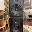 Dvě černé studiové monitory v základním obdélníkovém tvaru, které jsou naskládány na sebe. Na horní i spodní části je v horním okraji nápis BX5a a v…