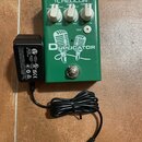 Zelený efekt pedál s bílým nápisem Duplicator a grafikou dvou mikrofonů. V horní části je bílý nápis TC HELICON a tři ovládací knoflíky s popisky DOU…