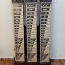 Tři stejné lap steel kytary s tmavým dřevěným tělem a světlými hmatníky. Hmatníky jsou opatřeny černými geometrickými značkami a v dolní části řadami…