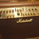 Kytarový kombo zesilovač značky Marshall s hnědým texturovaným povrchem a zlatým ovládacím panelem. Panel obsahuje sekce Acoustic Channel 1, Acoustic…