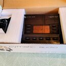 Černý elektronický přístroj Live Player LP-16 značky cymatic audio v originálním balení s bílým polystyrenem. Na přední straně je displej, ovládací t…