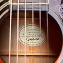 Detail vnitřku akustické kytary s viditelnou štítkovou nálepkou. Na nálepce je uveden Model EJ-200SCE/VS, číslo 15052314052 a logo Epiphone s nápisem…