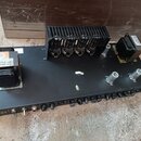 Černý elektronický přístroj v otevřeném šasi bez krytu. Na předním panelu je nápis VK 212, několik přepínačů a řada otočných ovladačů. Uvnitř jsou vi…
