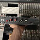 Černý rackový kompresor a limiter s nápisem COMPRESSOR LIMITER. V levé části je bílé logo DVR a červený přepínač. Zařízení má čtyři červené otočné kn…