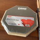Šestiúhelníkový cvičný pad značky EVANS REALFEEL v originální plastové fólii. Povrch je šedý s bílým logem EVANS REALFEEL v horní části. Na produktu…