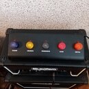Černý kytarový zesilovač značky SubZero s pětiknobečkovým ovládacím panelem. Nad knobíky jsou nápisy CLEAN, CRUNCH, OVERDRIVE, LEAD a METAL. Povrch p…