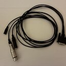 Černý kabel s několika konektory. Na jednom konci je široký vícepinový konektor typu D-Sub, na druhém jsou tři zakončení: jeden stříbrný kovový konek…
