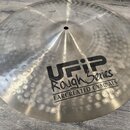 Kovový činel s kovaným povrchem a viditelnými důlky. Na povrchu je černý nápis UFIP Rough Series EARCREATED CYMBALS. V horní části je malý, nečitelný…