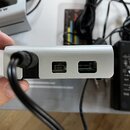 Detailní pohled na zadní stranu stříbrného elektronického zařízení s kovovým povrchem. Jsou vidět dva konektory, z nichž jeden je USB typ B a druhý j…