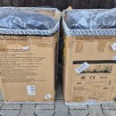 Dvě kartony s nápisem Active 1000-Watt 2-Way 15" PA Speaker System with Wireless Option and Integrated Mixer. Uvnitř jsou vidět černé reproduktory za…