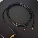 Černý audio kabel s pozlacenými konektory. Na jednom konci je 6,35mm jack a na druhém konci jsou dva menší pozlacené konektory. Kabel je svinutý do k…