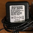 Černý plastový AC/DC adaptér značky electro-harmonix s bílou nálepkou. Na nálepce je uveden text: AC/DC ADAPTOR, For I.T.E. used only, Nur für IT-und…