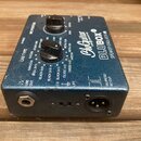 Modrý efektový pedál s nápisy BluGuitar TONE INNOVATION a BLUBOX SPEAKER EMULATOR IR. Na horní straně jsou dva černé ovládací knoflíky a různé textov…