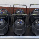 Deset kusů černých světelných efektů v plastovém provedení s úchytky z kovových trubek. Každý jednotka má na horní straně digitální displej a ovládac…