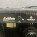 Zadní strana kytarového komba v černém texturovaném potahu. Na černém štítku jsou nápisy „CE“, „230V ~ 50/60 Hz 200 WATTS“ a varovné upozornění „CAUT…