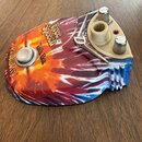 Kytarový efekt Talk Box s barevným vzorem tie-dye v červených, žlutých a modrých odstínech. Na povrchu jsou nápisy „Free Speech™“, „Talk Box“ a logo…