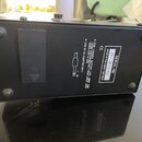 Fotografie zachycuje spodní stranu černého efektpedálu s čtyřmi gumovými nožičkami. Na povrchu je bílý štítek s nápisy „SERIAL №: SV-980096“, „MADE I…