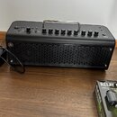 Černý kombozesilovač s kovovou rukojetí a mřížkou reproduktoru. Na levé straně je logo Yamaha. Horní panel obsahuje ovládací knoflíky s popisky: GAIN…