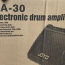 Fotografie krabice od elektronického zvučovace s nápisem DA-30 Electronic drum amplifier. Na krabici je uveden seznam technických parametrů a obrázek…