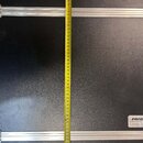Fotografie zachycuje vnitřek černého transportního kufru s hliníkovými hranami a profilovými lištami. Uprostřed je natažený žlutý metr, který ukazuje…
