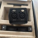 Černý elektronický modul s dvěma konektory XLR. Pod konektory jsou nápisy DMX OUT 1 a DMX OUT 2, nad nimi se nacházejí kovová tlačítka s nápisem PUSH…