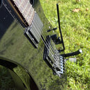Detail černé elektrické kytary s hnedým hmatníkem. Nástroj má dva černé humbuckery a černý tremolo systém s páčkou. Na povrchu laku jsou viditelné dr…