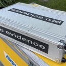 Stříbrný transportní kufr z texturovaného materiálu s hliníkovými hranami a kovovým zapínáním. Na horní straně i na přední čelní straně je černý nápi…