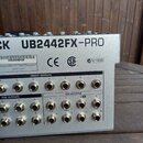 Zadní strana stříbrného mixážního pultu s nápisem UB2442FX-PRO a částečně viditelným označením CK. Na šasi jsou loga CE, SA (C US) a nápis N11999, dá…