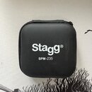 Černý, čtvercový pevný obal s zipem. Na přední straně je bílým tiskem logo Stagg® a pod ním označení SPM-235. Povrch obalu je v dobrém stavu bez vidi…
