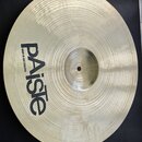 Kruhový mosazný činel s koncentrickým žebrováním povrchu. Na povrchu je černý nápis „Paiste“ a pod ním menší text „MADE IN SWITZERLAND“. Činel je pol…
