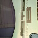 Detail bílého povrchu hudebního nástroje s nápisy. Je zde vidět velký vertikální text MOTION a menší nápisy SUPER EDITION, MB-III YAMAHA. Vedle nich…