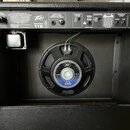 Zadní strana černého kytarového komba s texturovaným povrchem. Na horním ovládacím panelu jsou nápisy Peavey, BANDIT 112 a sekce SPEAKER SIMULATED DI…