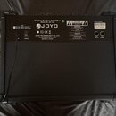 Zadní strana černého kytarového komba s texturovaným povrchem. Na horní části je umístěn štítek s nápisy Digital Guitar Amplifier, Model No.:DC-30 a…