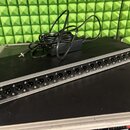 Stříbrný rackový panel s řadou 16 konektorů XLR. Pod každým konektorem je bílý nápis od OUT 1 až OUT 16. Vlevo na černém panelu je viditelný nápis DC…
