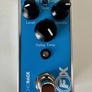 Modrý efekt pedál s kovovým rámem. Na horní straně jsou tři černé otočné knoflíky s popisky Level, Repeats a Delay Time,以及 přepínač Tape s nápisy Ana…