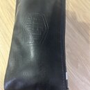 Černý obal z umělé kůže s zipem na boku. Na povrchu je vyražený nápis METAL STUDIO v šestiúhelníkovém rámu. Povrch materiálu vykazuje mírné pomačkání…