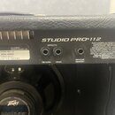 Zadní strana černého kytarového komba s texturou kůže. Na černé ovládací liště je bílý nápis STUDIO PRO® 112 a EFFECT S s dvěma vstupy označenými RET…