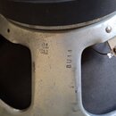 Detail reproduktoru s kovovým rámem stříbrné barvy. Na horní části je vidět bílá nálepka s nápisy CELESTION, H-100 a TYPE NO. Na kovovém rámu jsou vy…