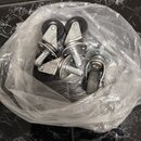 V průhledném plastovém sáčku se nachází několik kusů kovových koleček s černými gumovými plášti. Kovové části mají stříbrnou barvu a jsou vybaveny mo…
