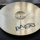 Kovový činel zlatavé barvy s koncentrickými rýhami na povrchu. V dolní části je černý nápis pAiste a pod ním menší text MADE IN SWITZERLAND. Činel je…
