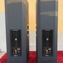 Dva černé plastové reproduktory v plastových krytech. Na zadní straně každého reproduktoru je vidět ovládací panel s logem JBL a nápisem EON. Povrch…