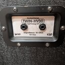 Detail zadní strany kytarového boxu s černým rámečkem a bílým štítkem. Na štítku je uveden nápis Rockwellamps, model TWIN-HV30 a specifikace 2x12"Vin…